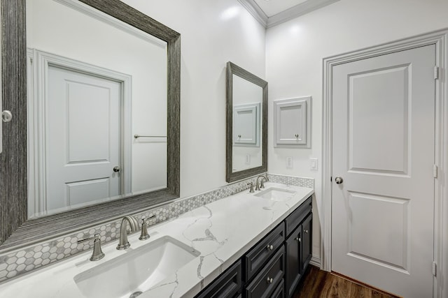 full bathroom featuring crown molding, a sink, wood finished floors, and double vanity
