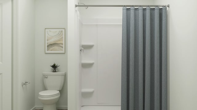full bathroom with toilet and a shower with curtain