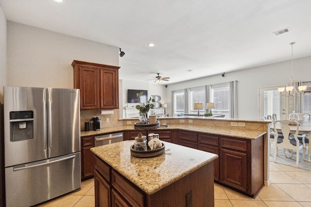 kitchen featuring appliances with stainless steel finishes, ceiling fan with notable chandelier, a peninsula, light tile patterned floors, and visible vents