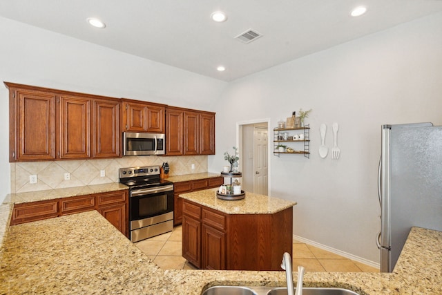 kitchen featuring light tile patterned flooring, a sink, stainless steel appliances, decorative backsplash, and visible vents