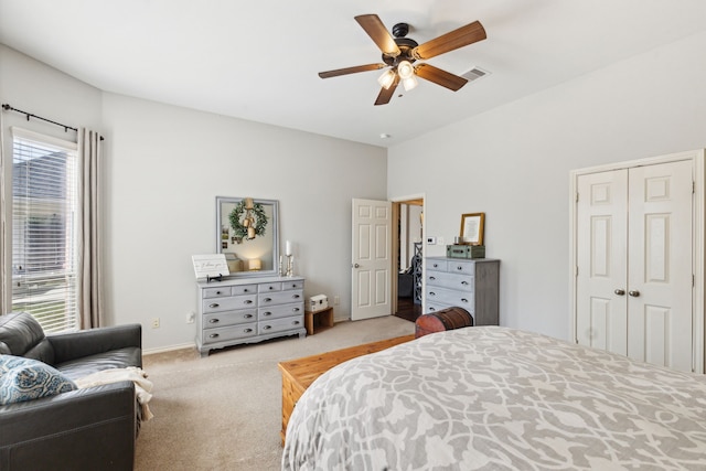 bedroom featuring visible vents, a closet, light carpet, baseboards, and a ceiling fan