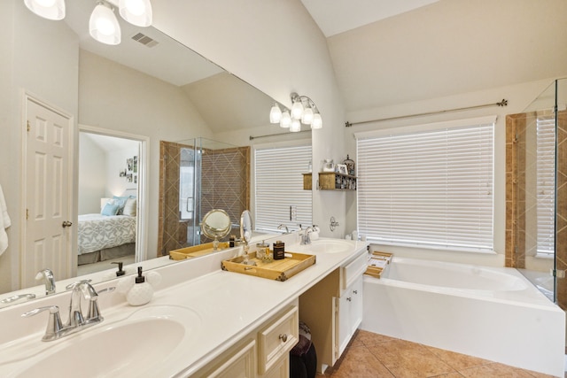 bathroom featuring a sink, tile patterned floors, a stall shower, and ensuite bath