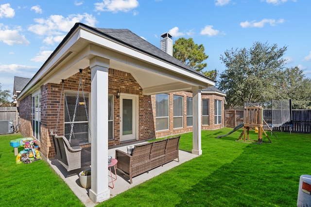 back of house with fence, a trampoline, brick siding, an outdoor hangout area, and a patio