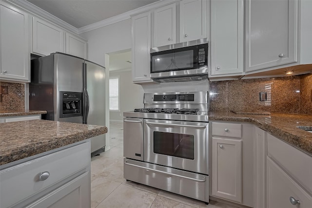 10310 Sable Trail Ln, Houston, TX 77064 - kitchen with appliances with stainless steel finishes, ornamental molding, light tile patterned floors, backsplash, and dark stone counters