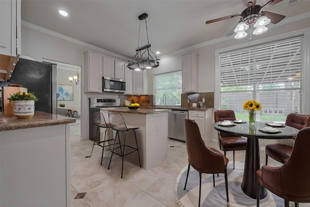 10310 Sable Trail Ln, Houston, TX 77064 - kitchen featuring stainless steel appliances, crown molding, backsplash, a center island, and ceiling fan