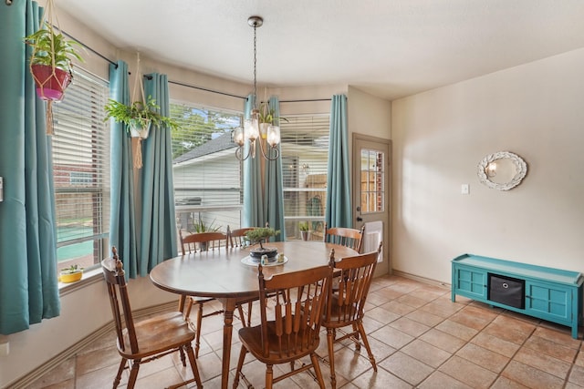 dining room with light tile patterned flooring, baseboards, and a chandelier