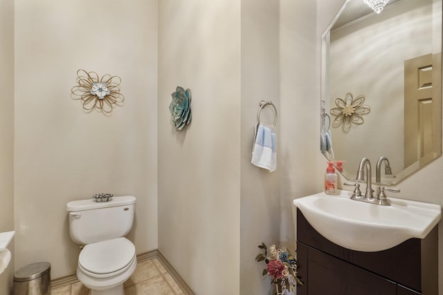 bathroom featuring vanity, baseboards, tile patterned floors, and toilet