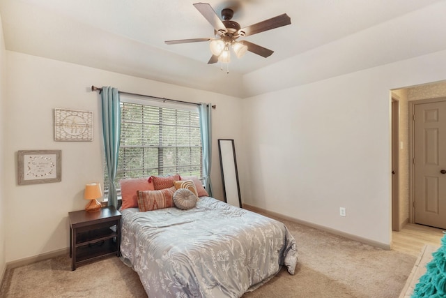 bedroom with a ceiling fan, baseboards, and light carpet