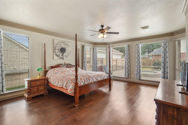 bedroom with crown molding, ceiling fan, a textured ceiling, wood finished floors, and visible vents