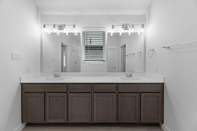 bathroom with a sink, baseboards, and double vanity