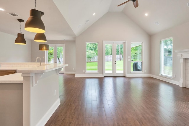 unfurnished living room featuring a wealth of natural light, a ceiling fan, french doors, and visible vents