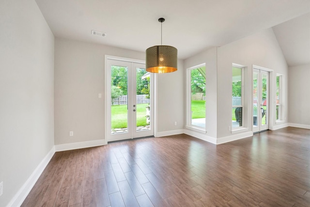 interior space featuring baseboards, lofted ceiling, dark wood-style flooring, and visible vents