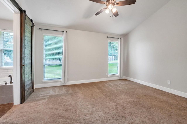 empty room with ceiling fan, carpet, baseboards, and lofted ceiling