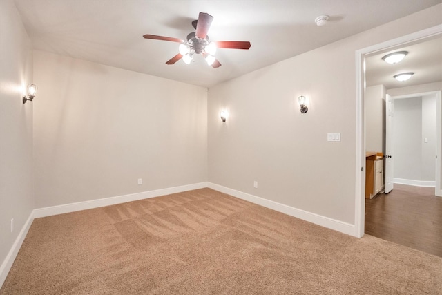 carpeted empty room with baseboards and a ceiling fan