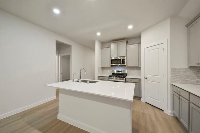 1710 Portia Ln, Conroe, TX 77301 - kitchen with a sink, appliances with stainless steel finishes, gray cabinets, and tasteful backsplash