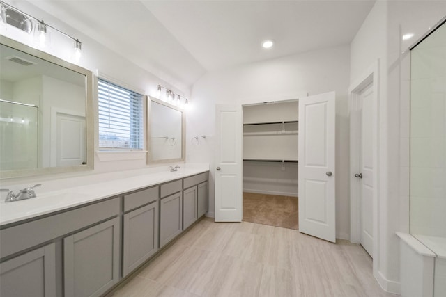1710 Portia Ln, Conroe, TX 77301 - bathroom featuring visible vents, double vanity, an enclosed shower, a spacious closet, and a sink