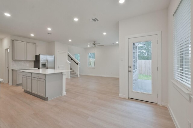 kitchen with visible vents, gray cabinets, tasteful backsplash, and stainless steel fridge with ice dispenser