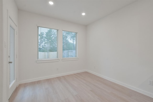 spare room with recessed lighting, light wood finished floors, and baseboards