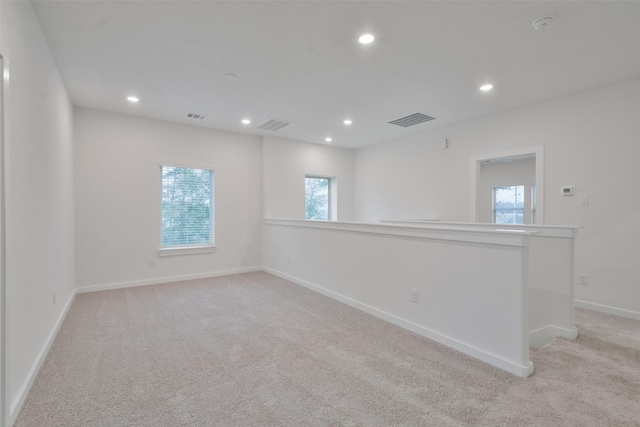 spare room featuring visible vents, recessed lighting, baseboards, and light colored carpet