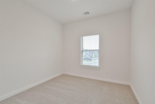 empty room with light colored carpet, baseboards, and visible vents