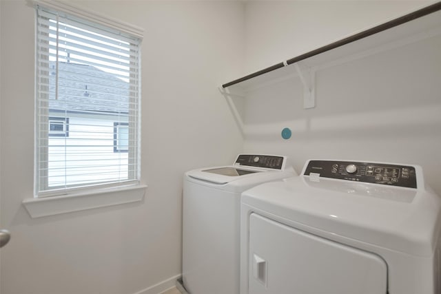 washroom with separate washer and dryer, laundry area, plenty of natural light, and baseboards