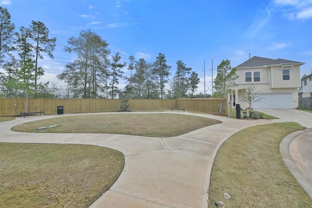 exterior space featuring a lawn, fence, driveway, and a garage