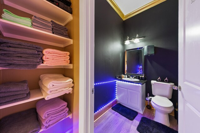12832 Willow Centre Dr, Houston, TX 77066 - half bath with vanity, ornamental molding, toilet, and wood finished floors