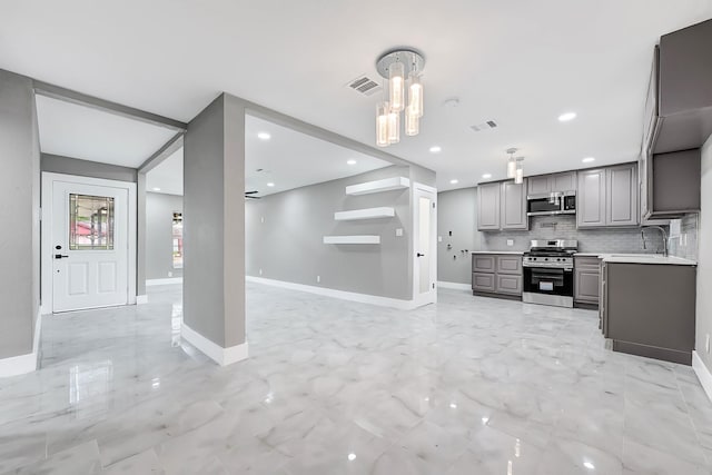 kitchen featuring appliances with stainless steel finishes, visible vents, light countertops, open floor plan, and gray cabinetry