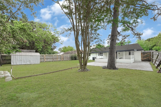 view of yard featuring a fenced backyard, a storage unit, a patio, and an outbuilding
