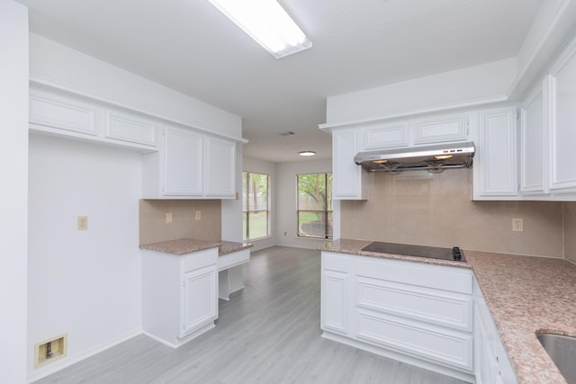 kitchen featuring light wood-style floors, under cabinet range hood, black electric stovetop, and white cabinetry