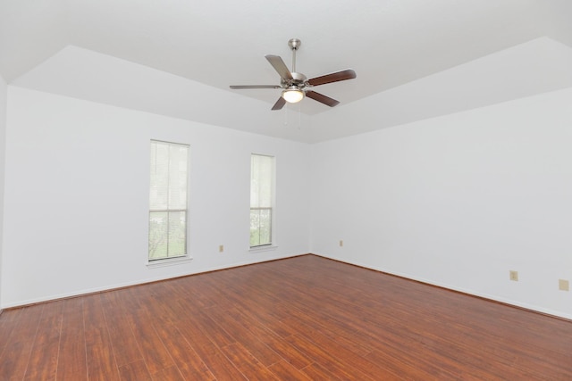 spare room with baseboards, ceiling fan, and dark wood-style floors