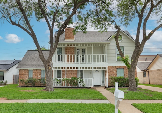 view of front of property featuring a porch, brick siding, and a chimney