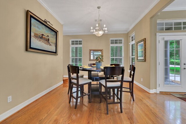 dining room with crown molding, light wood finished floors, and a notable chandelier
