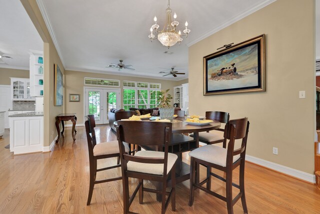 dining space featuring ornamental molding, light wood-style floors, baseboards, french doors, and ceiling fan with notable chandelier
