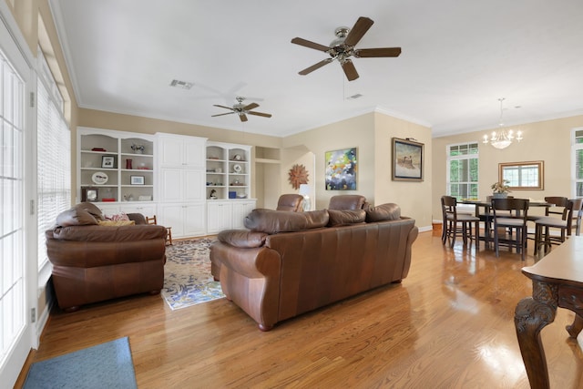 living room with visible vents, ornamental molding, light wood-style floors, and plenty of natural light