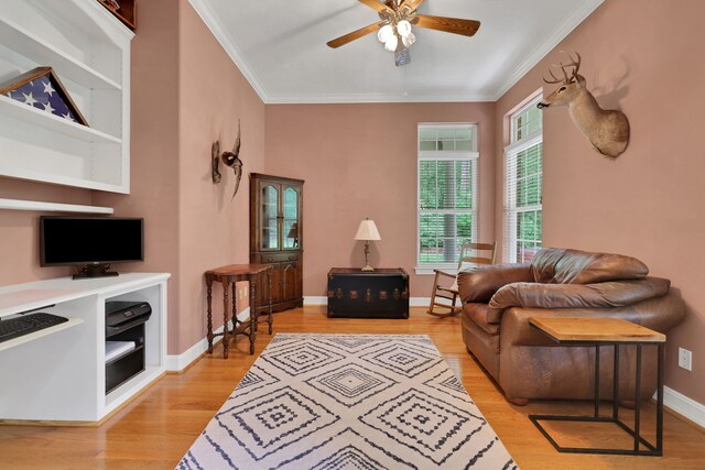 sitting room featuring crown molding, a ceiling fan, baseboards, and light wood-type flooring