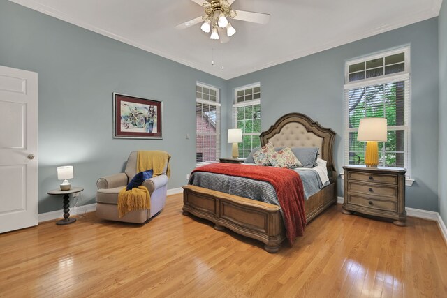 bedroom featuring wood-type flooring, crown molding, and multiple windows