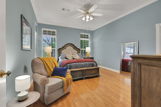 bedroom featuring visible vents, ornamental molding, light wood finished floors, and baseboards
