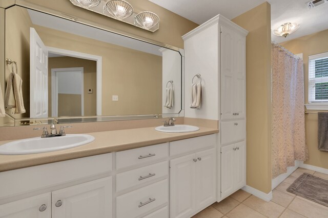full bathroom featuring a sink, tile patterned flooring, double vanity, and visible vents