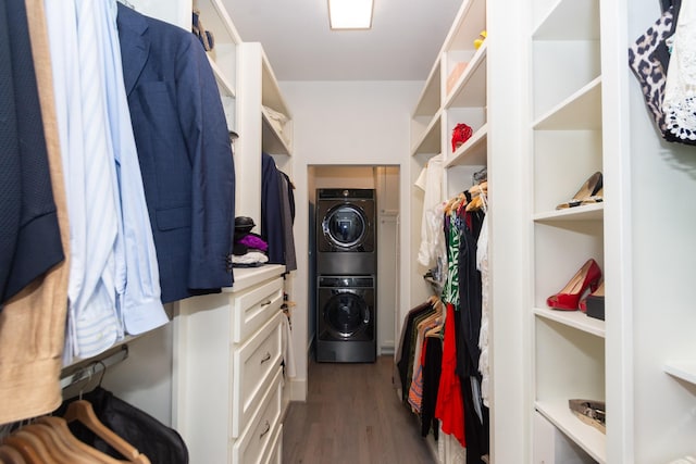 spacious closet featuring dark wood-style flooring and stacked washing maching and dryer