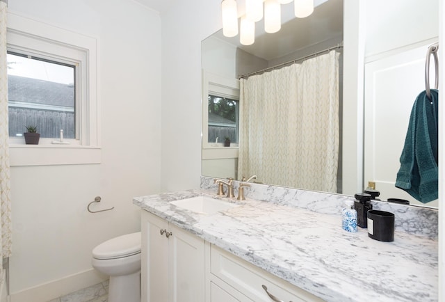 bathroom featuring baseboards, vanity, and toilet