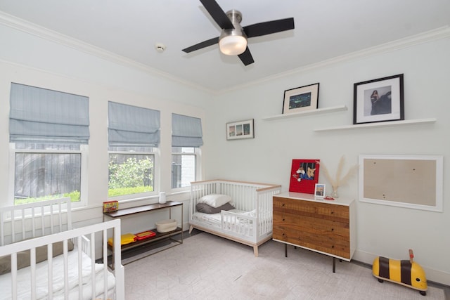 bedroom featuring ceiling fan, ornamental molding, and a crib