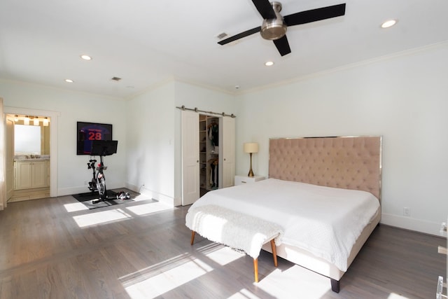bedroom featuring baseboards, ornamental molding, recessed lighting, and a barn door