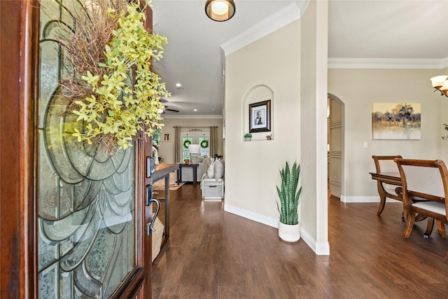 foyer featuring crown molding, arched walkways, baseboards, dark wood-style floors, and recessed lighting