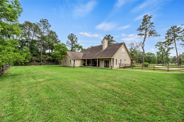 30710 N Holly Oaks Cir, Magnolia, TX 77355 - rear view of house featuring a lawn, a patio, a chimney, and a fenced backyard