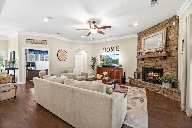 living area featuring visible vents, a ceiling fan, a stone fireplace, recessed lighting, and arched walkways