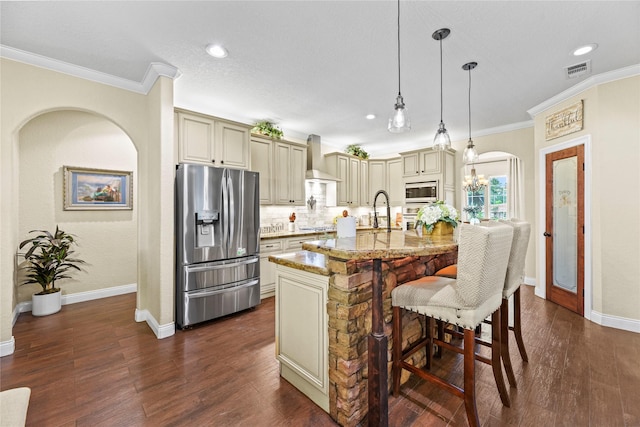kitchen featuring visible vents, crown molding, appliances with stainless steel finishes, cream cabinets, and light stone countertops