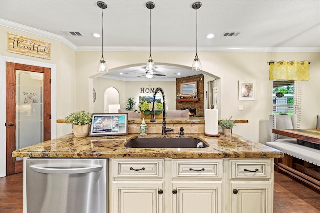 kitchen with stainless steel dishwasher, ornamental molding, ceiling fan, cream cabinets, and a sink