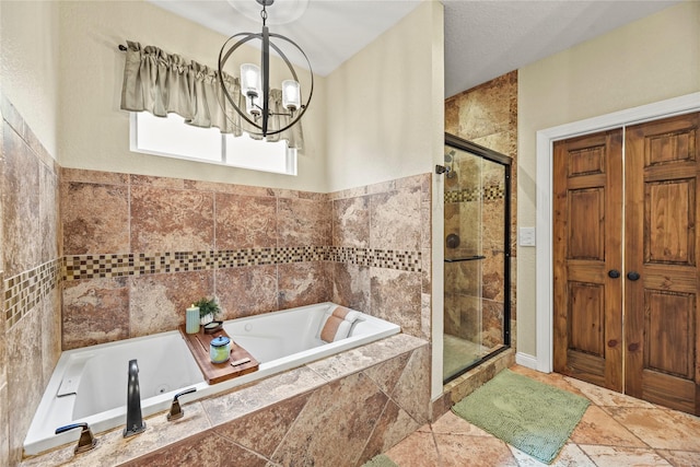 bathroom with a shower stall, a tub with jets, and a notable chandelier