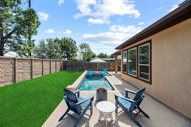 view of pool featuring a patio, a fenced backyard, an outdoor fire pit, and a yard